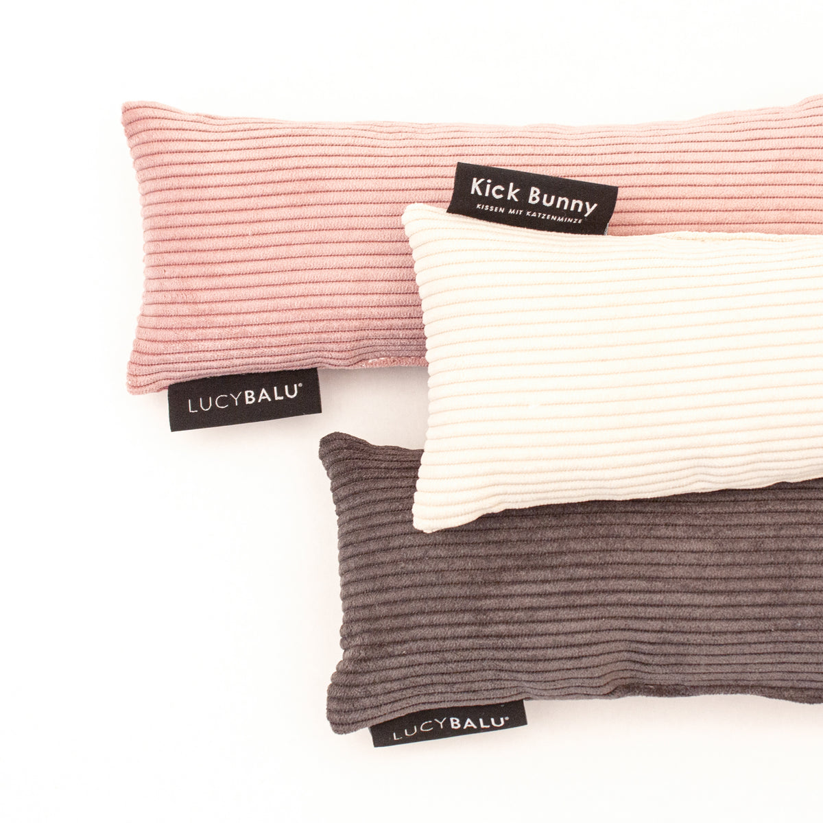 Bunny Kick Kissen aus Cord in drei Farben flach arrangiert auf hellem Hintergrund