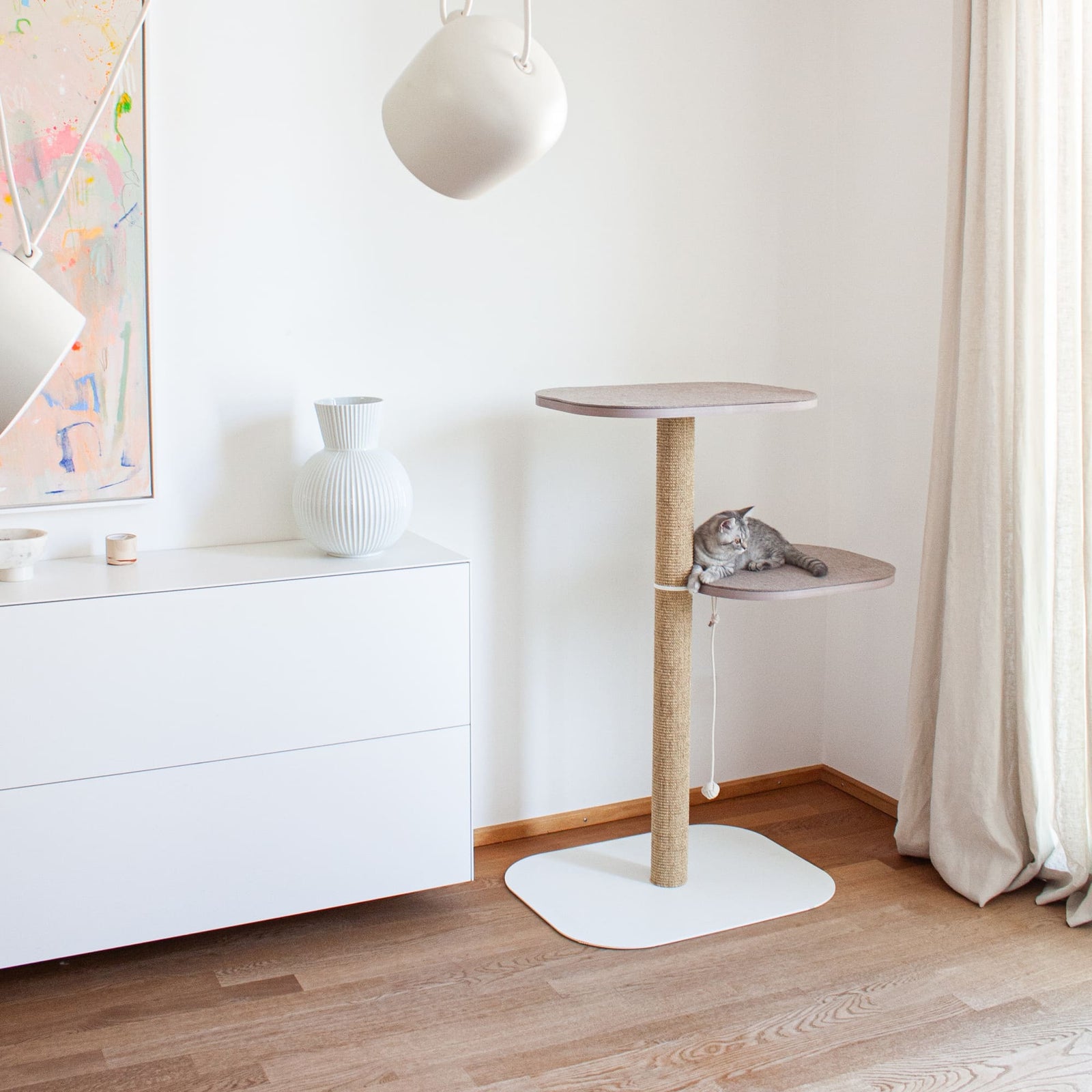 Minimalistischer Kratzbaum in Weiß mit Sisalstamm und Filz-Liegefläche – hochwertige Katzenmöbel im Wohnzimmer.