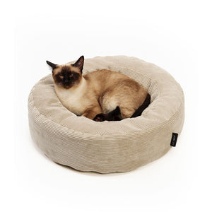 Siamkatze liegt ausgestreckt im gemütlichen LucyBalu Katzenbett aus beigem Cord.