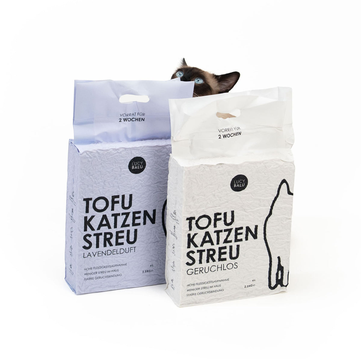 Zwei Beutel Tofu Katzenstreu nebeneinander, zwei Varianten: Geruchlos und Lavendel, Katze schaut von hinten darüber