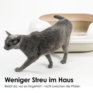 Katze steigt aus Katzenklo gefüllt mit  Tofu Katzenstreu in der Variante Geruchlos