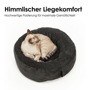 Katze ruht im anthrazitfarbenen Cordbett mit Text „Himmlischer Liegekomfort – Hochwertige Polsterung für maximale Gemütlichkeit